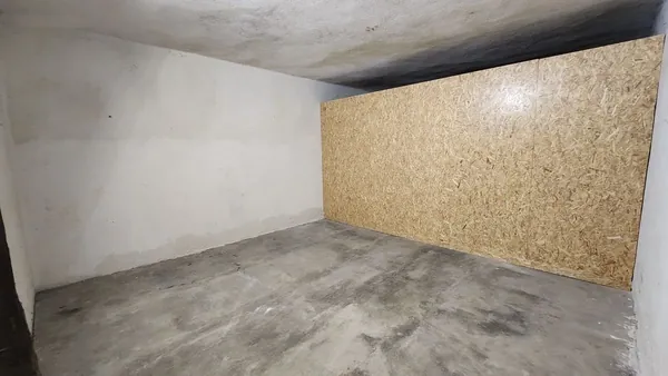 Box de stockage vide avec cloison en bois et sol en béton
