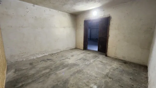Intérieur d’un box de stockage avec porte métallique et murs maçonnés